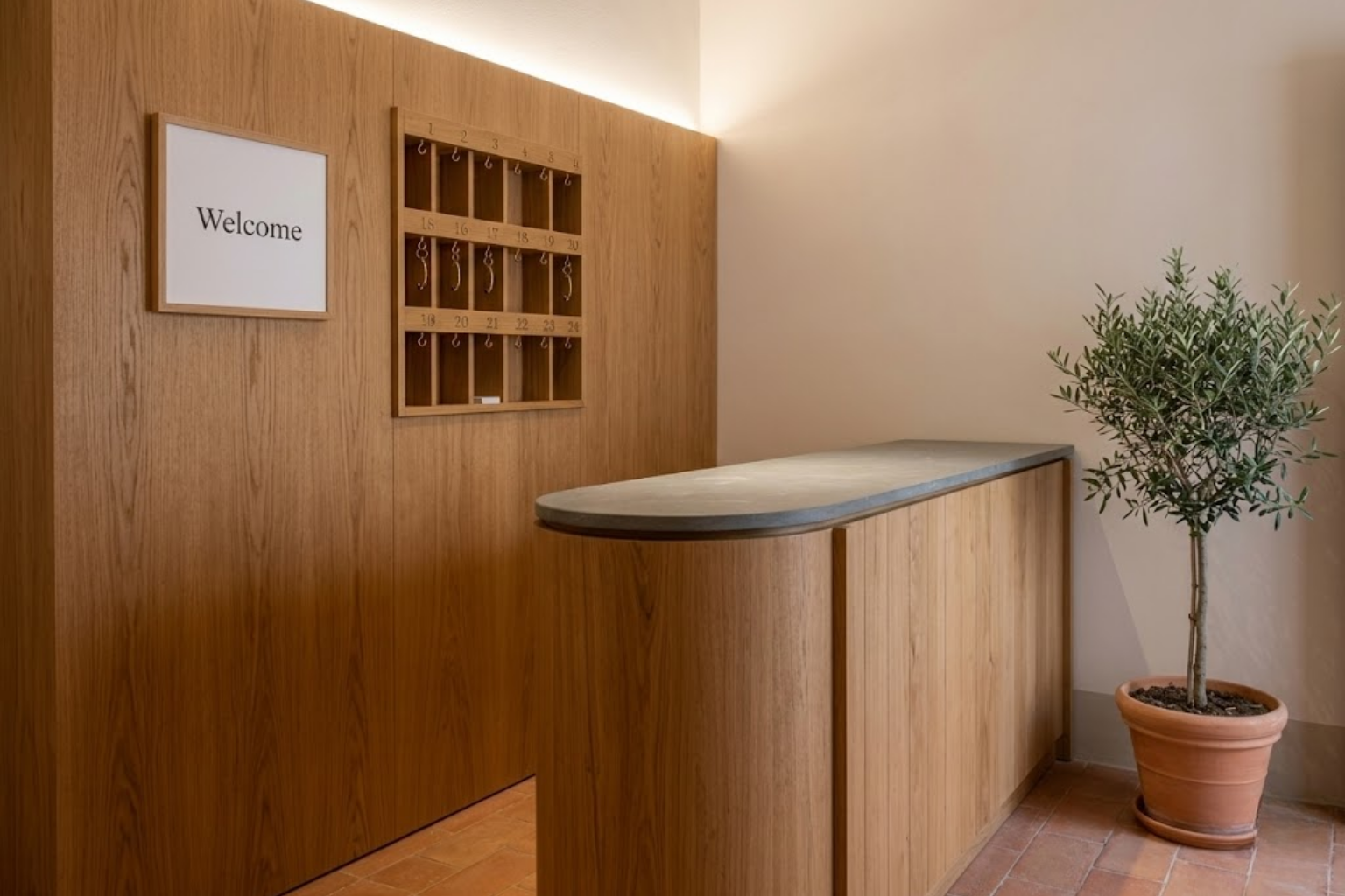 Banco reception compatto su misura in legno naturale per B&B a Messina